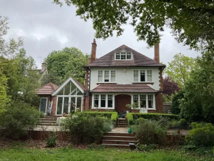 The garden elevation with three storeys, dormered roof and the 2008 glazed side extension