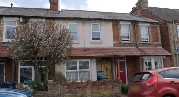 Front elevation of the Howard Street terrace before retrofit — solid brick under old paint, single-glazed windows