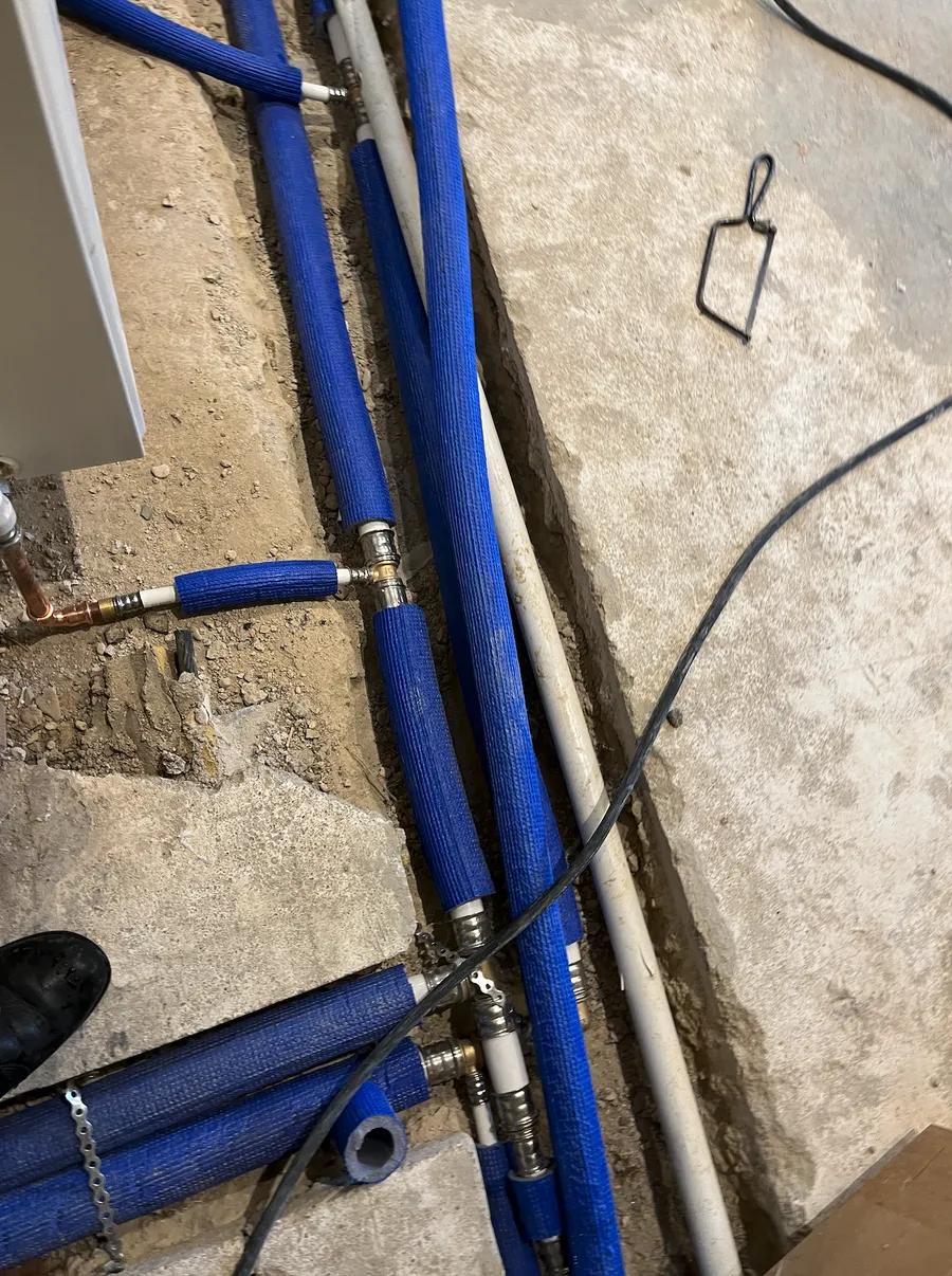 New insulated heating pipework laid in channels excavated across the solid floor