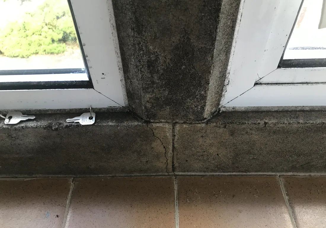 Black mould and a cracked cill at an uninsulated stone window mullion before the works